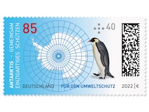 Kaiserpinguin betrachtet die Karte des Eisschildes mit Längen   und Breitengraden