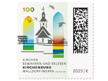 Hauptgebäude der Kirche zwischen zwei Glasfenstern die den Wiederaufbau zeigen.